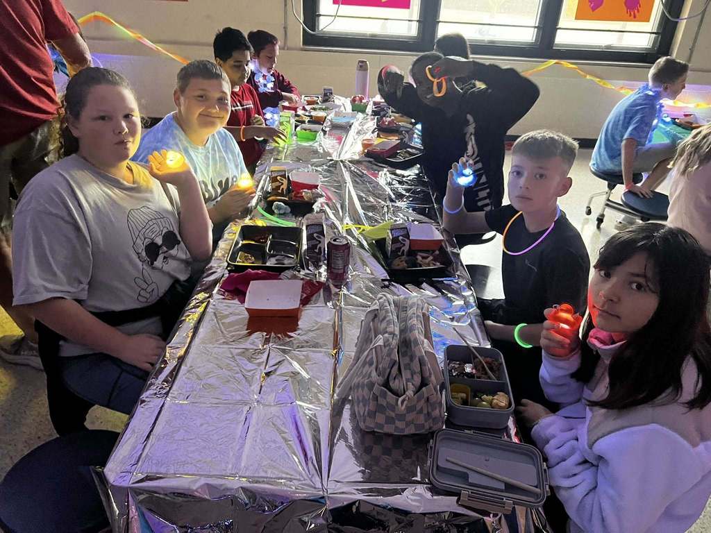 Barnes student having lunch while the glow lunch activities are going on around them.  
