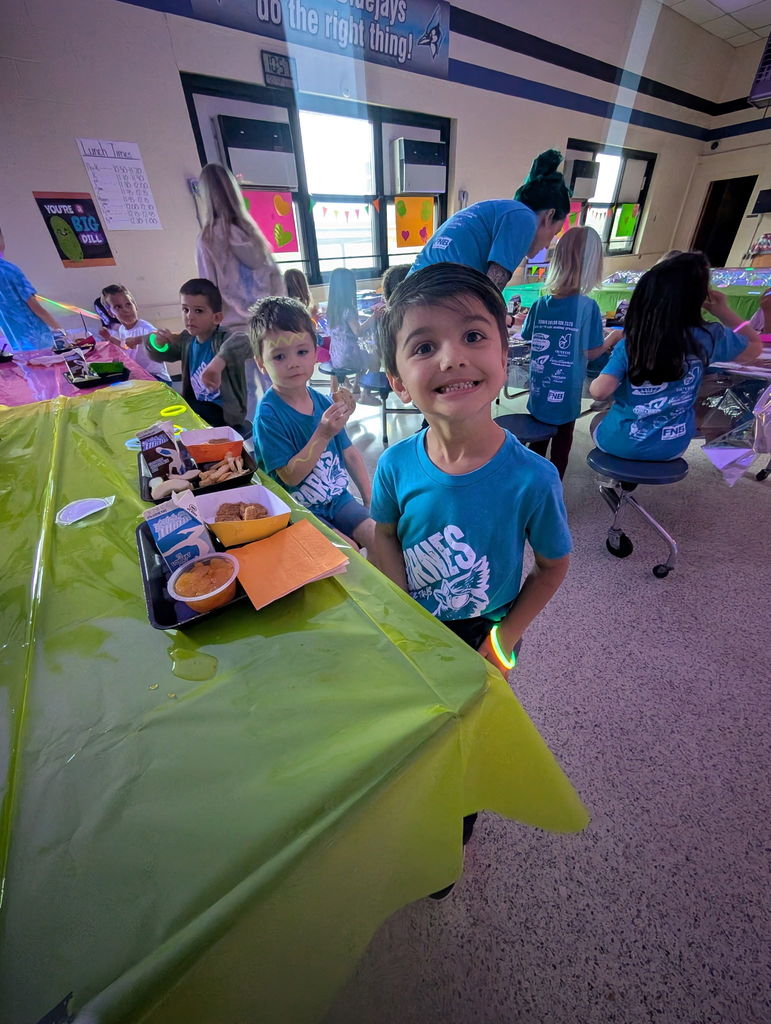 Barnes student having lunch while the glow lunch activities are going on around them.  