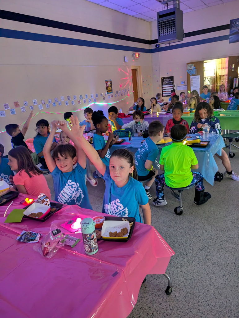 Barnes student having lunch while the glow lunch activities are going on around them.  