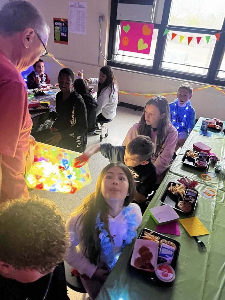 Barnes student having lunch while the glow lunch activities are going on around them.  