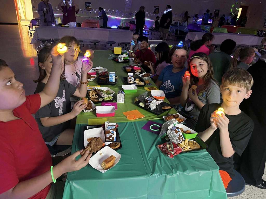 Barnes student having lunch while the glow lunch activities are going on around them.  