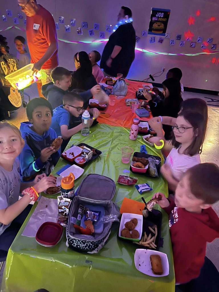 Pictures of students during the glow lunch. Barnes student having lunch while the glow lunch activities are going on around them.  