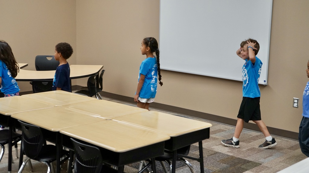 A student is amazed looking at the new classroom. His hands are on his head. 