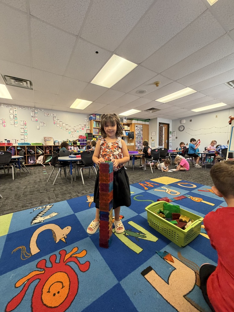 A Kindergarten student builds a tower in class.