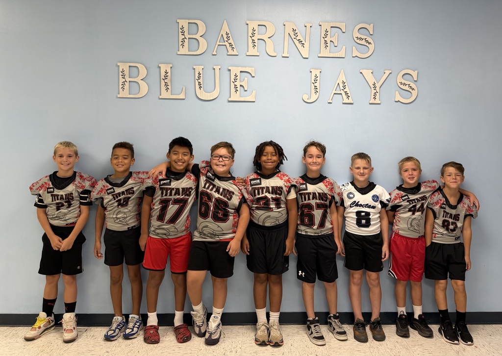 Barnes students who play football wear their jerseys to school and pose for a picture.