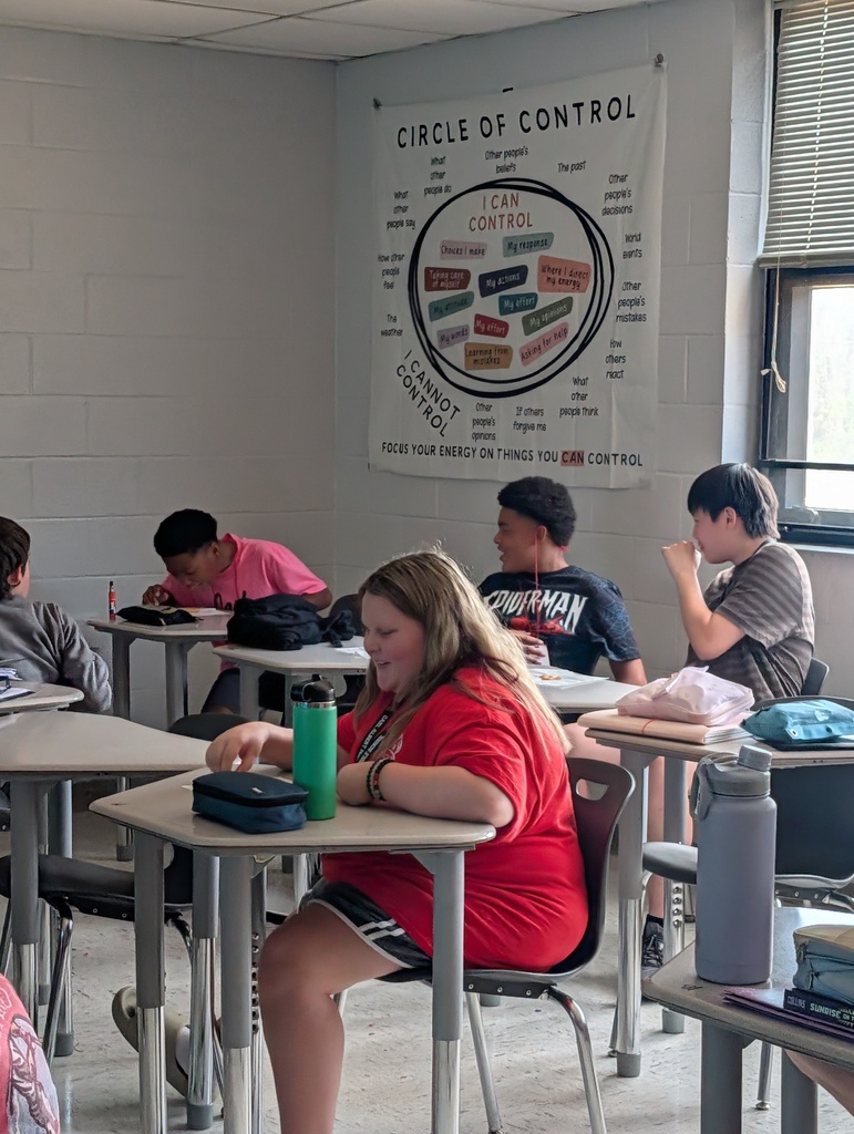 Five students seated at desks in a classroom with a banner that reads "Circle of Control".