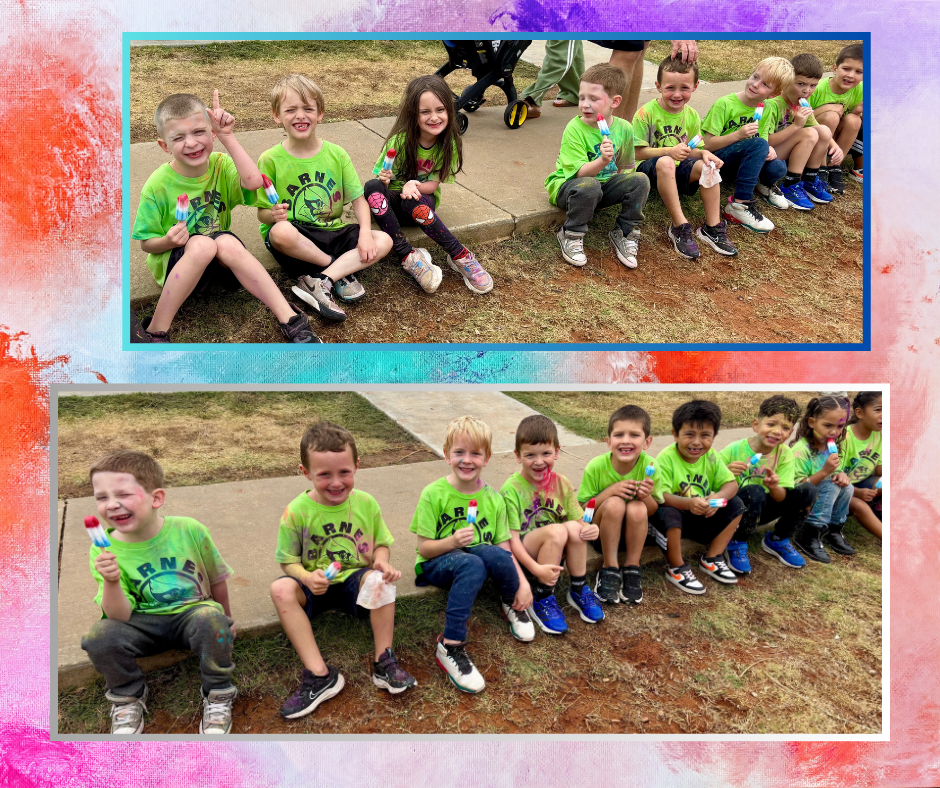 Two groups of children wearing green shirts, holding objects, sit on a concrete surface. Background has colorful paint.