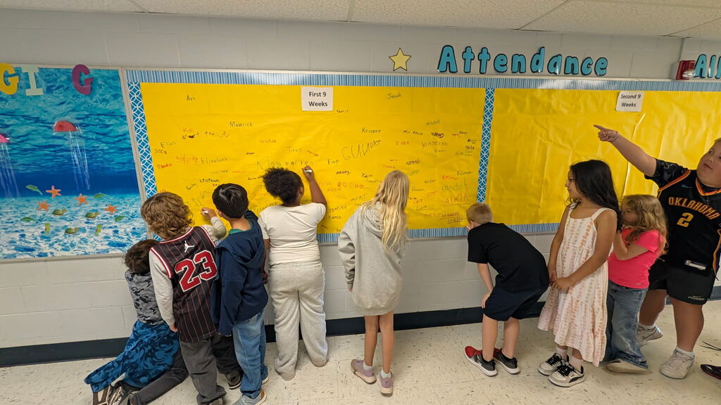 Students are shown signing the Attendance All Star Board for the 1st 9 weeks of school.