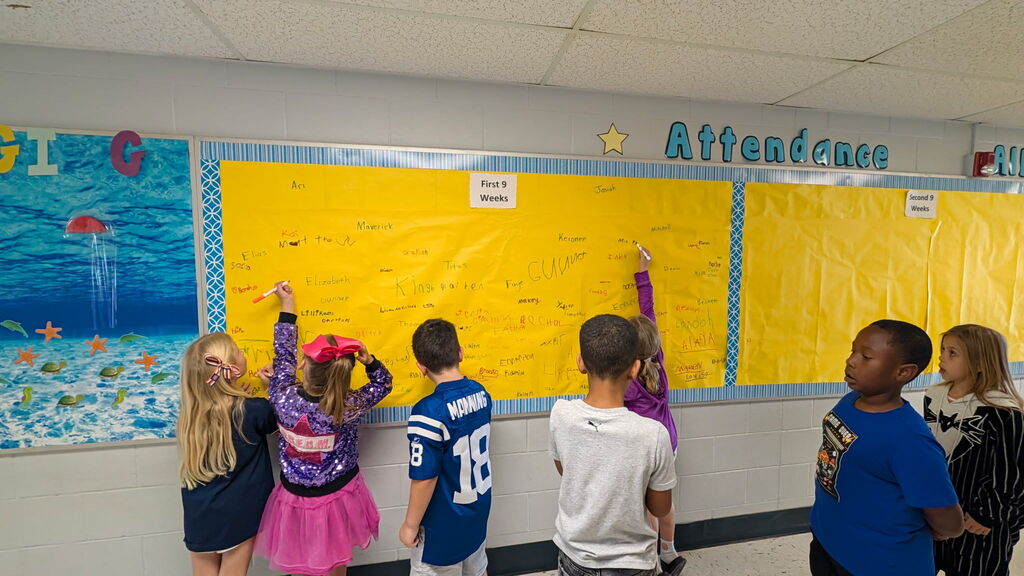 Students are shown signing the Attendance All Star Board for the 1st 9 weeks of school.