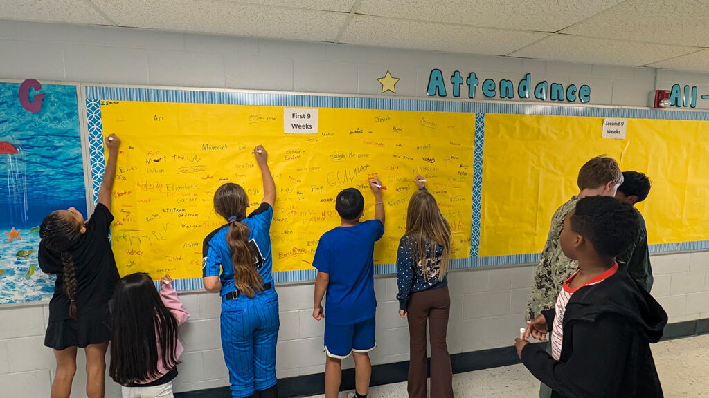 Students are shown signing the Attendance All Star Board for the 1st 9 weeks of school.