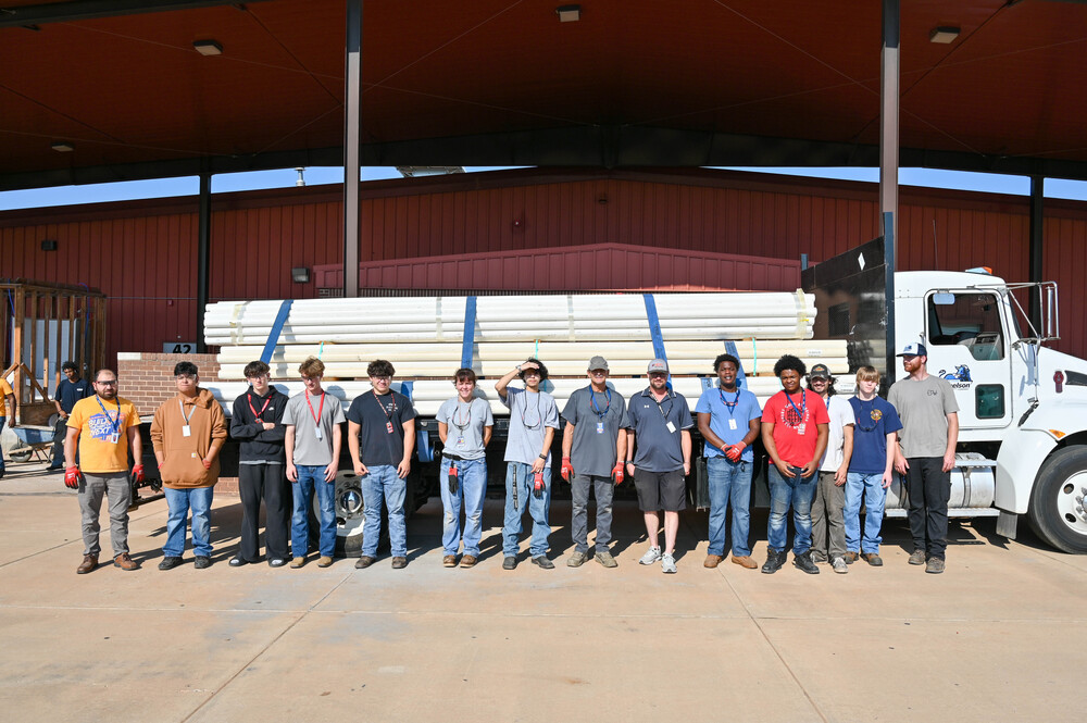 Plumbing students standing in front of the pipe donations