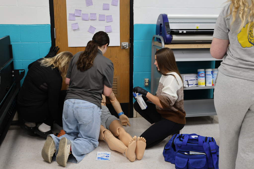emergency medical students in a classroom working on a simulated emergency
