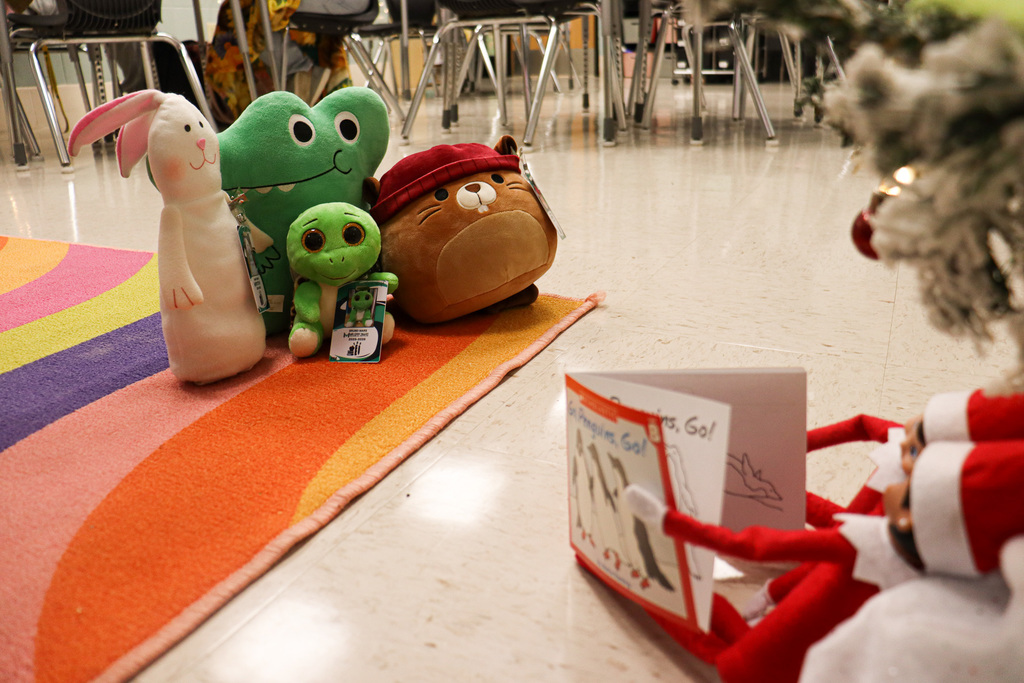 Mistletoe and Max "reading" to stuffed animals