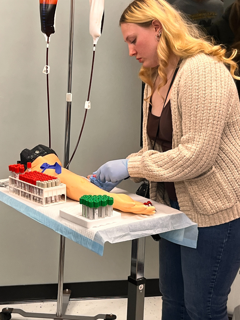 student simulating drawing blood
