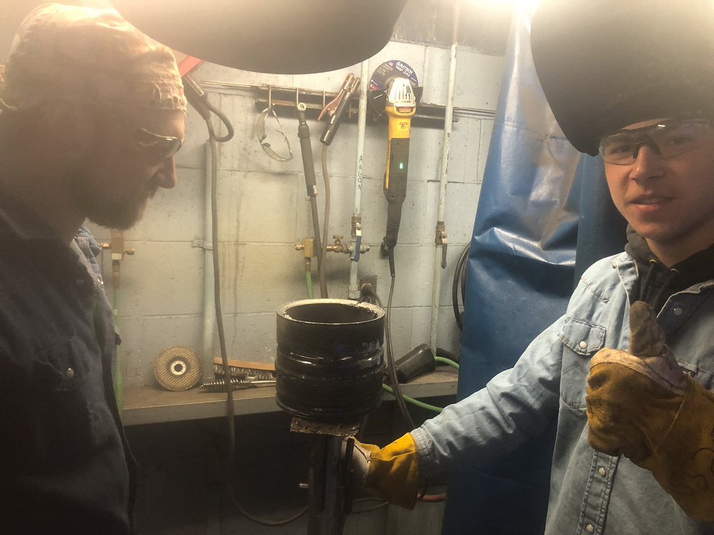 students working in welding booth