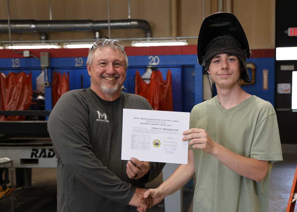 student and teacher with certificate