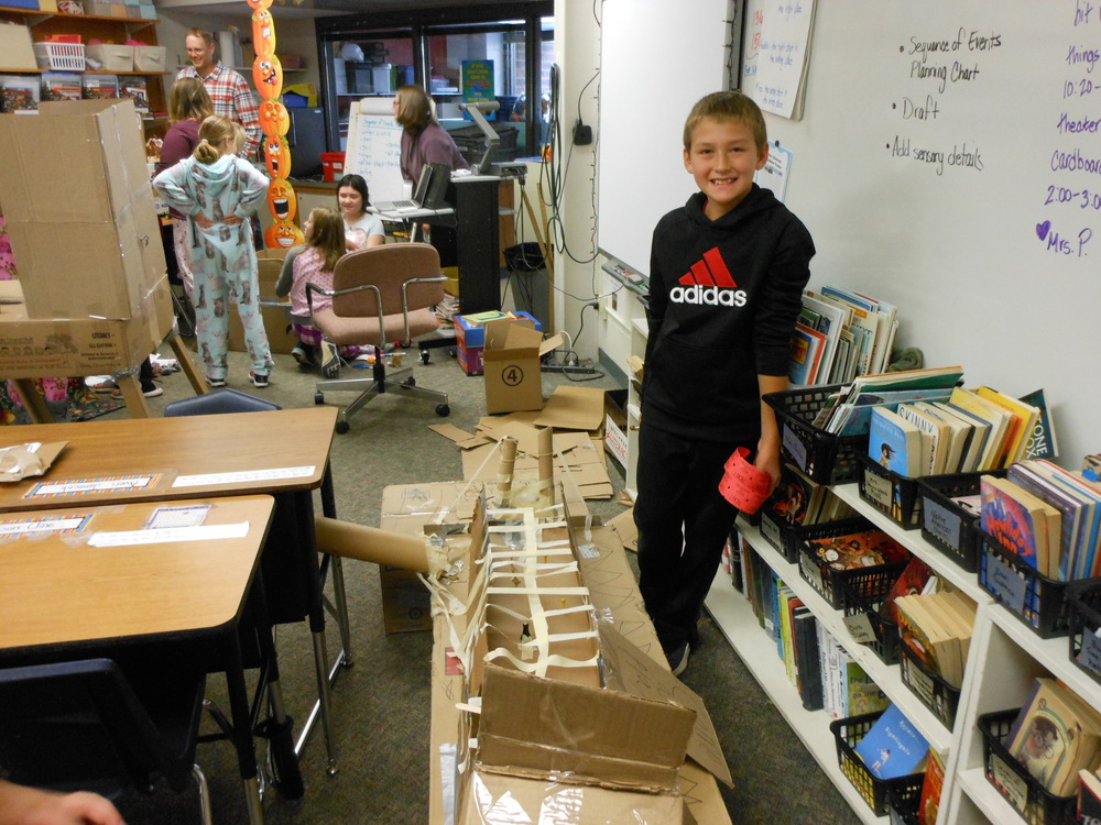 4th grade student displays his cardboard arcade game