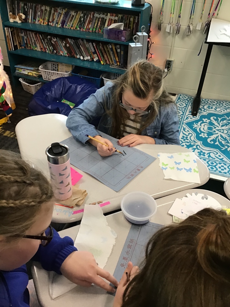 Students practice calligraphy
