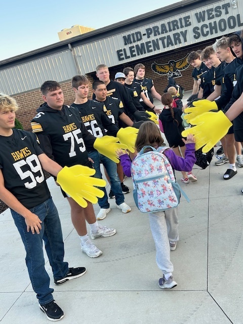 student walking in giving high fives