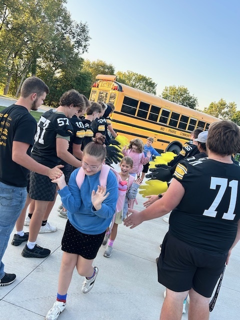 students walking in giving high fives