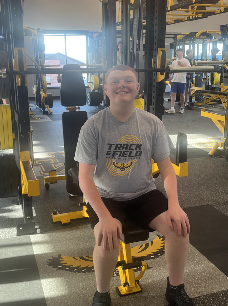 MP student Tate Jeffries sitting on a new weight equipment in the MP activities building