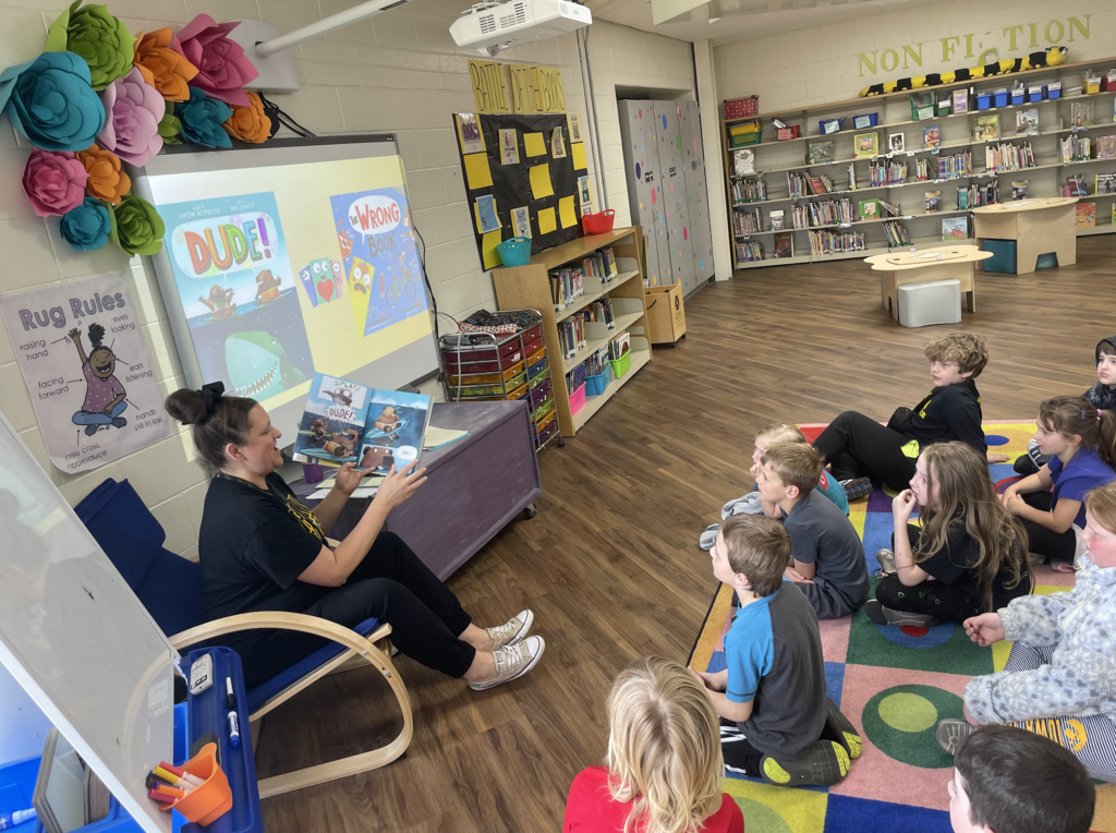 Jessica Dodds reading a book to students