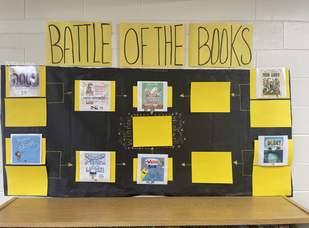 Battle of the Books bulletin board with book cover photos, two final books in the championship are Lucky Duck and The Wrong Book