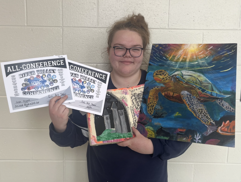 Student holding two of her artwork pieces, one a painting of a sea turtle and the other of a castle, and her all-conference awards