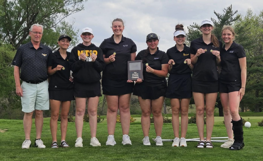 Girls golf team posing with coach and awrd plaque out on the course