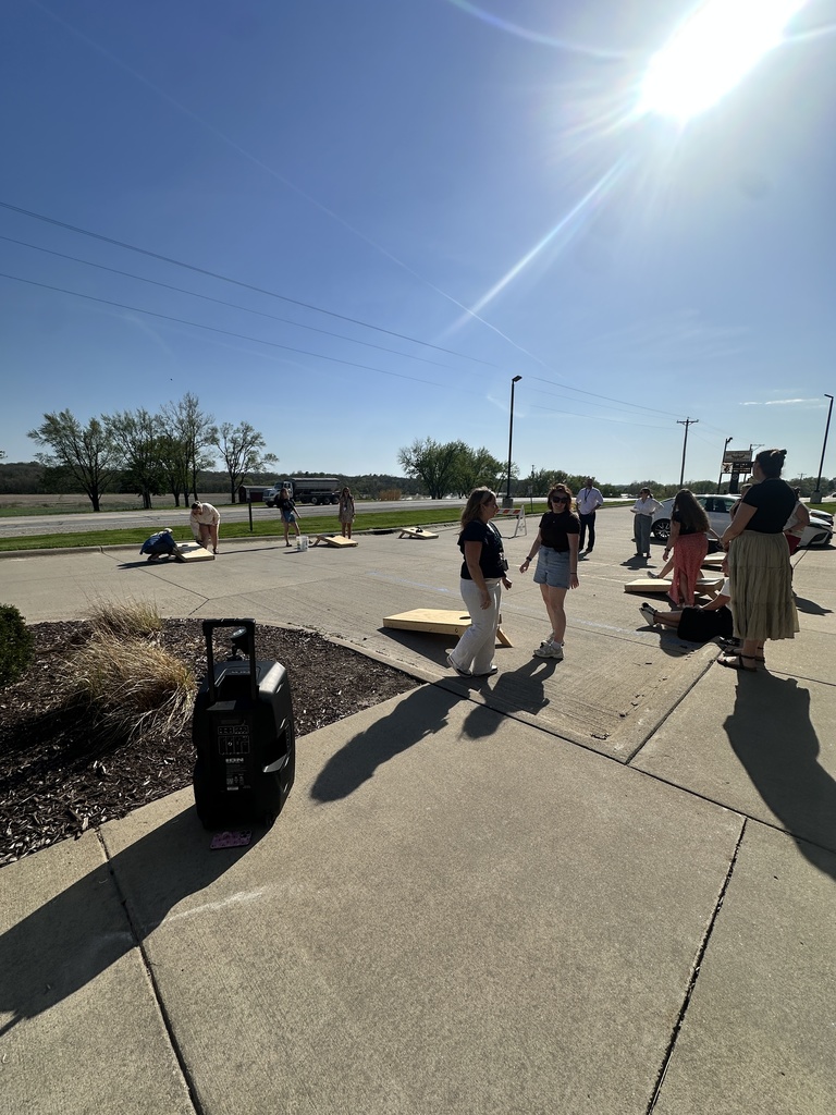 Teachers outside in the MP Central Office parking lot playing cornhole games int he parking spaces