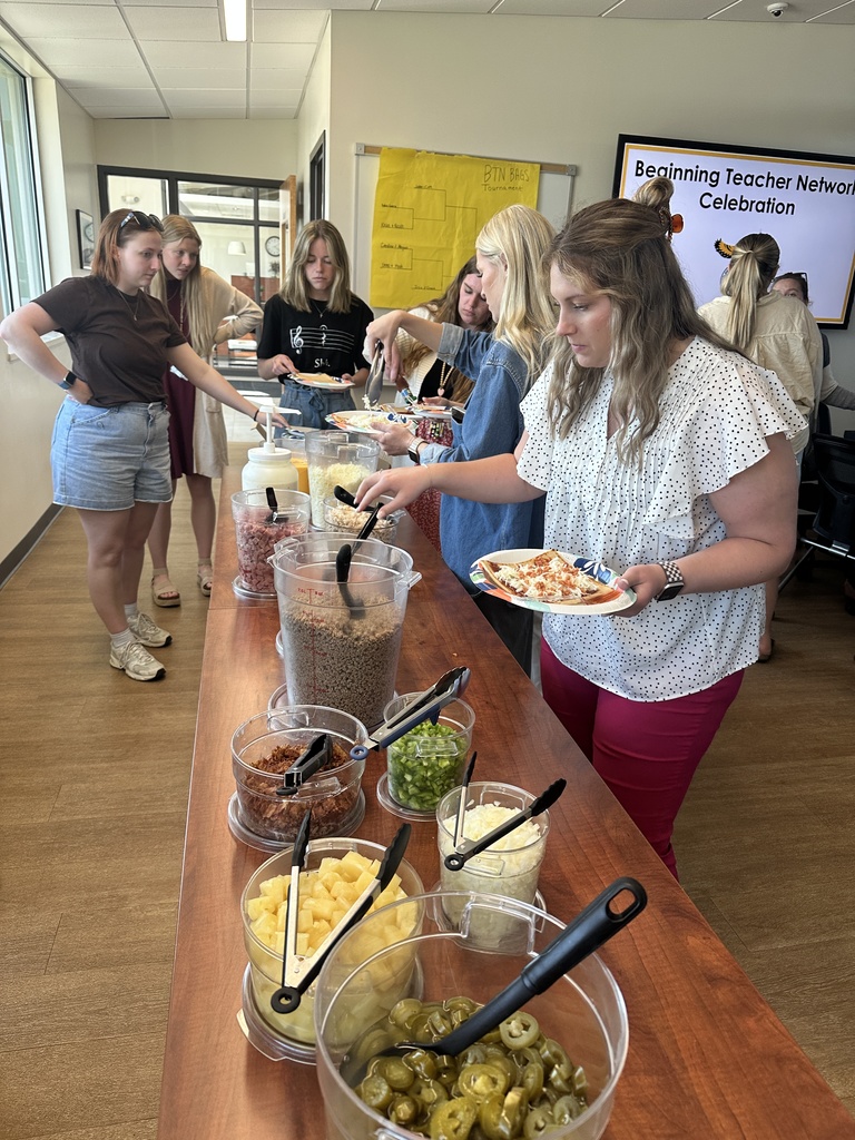 Teachers serving themselve through a buffet line of food prepared in the MP Central Office community room