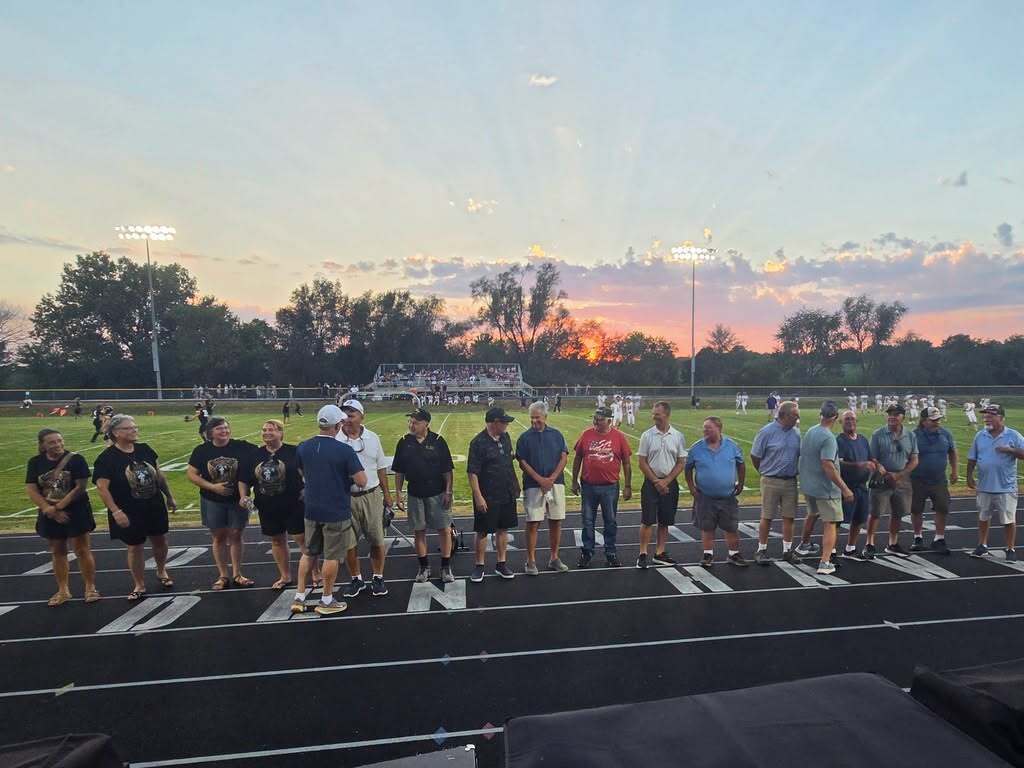 2001 Football team players standing on the track in front of a sunset over the football field