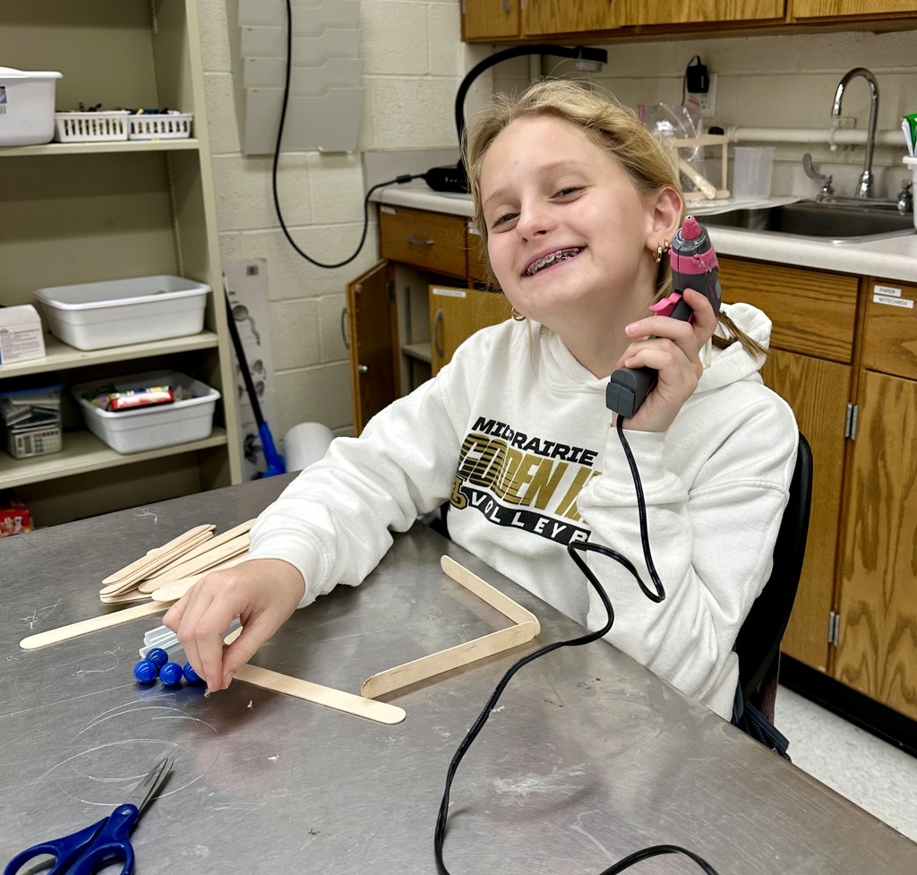 Student gluing popsicle sticks together