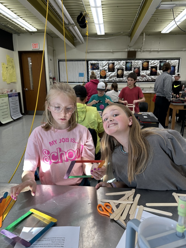 Student gluing popsicle sticks together
