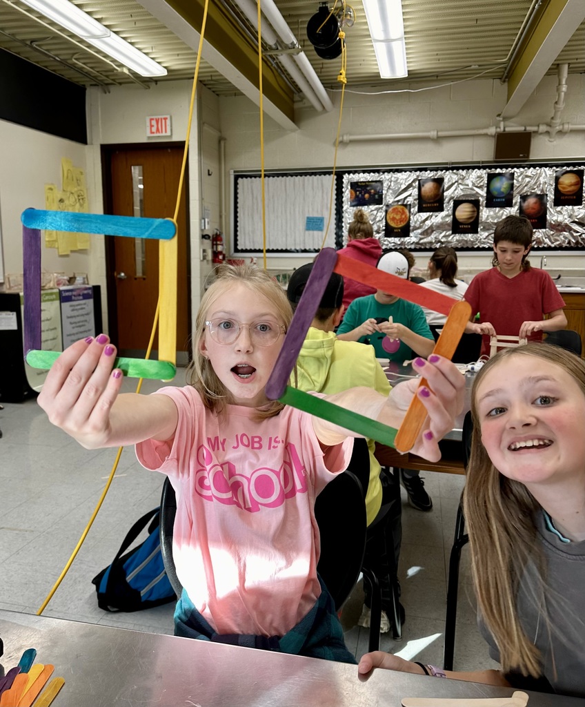 Student gluing popsicle sticks together