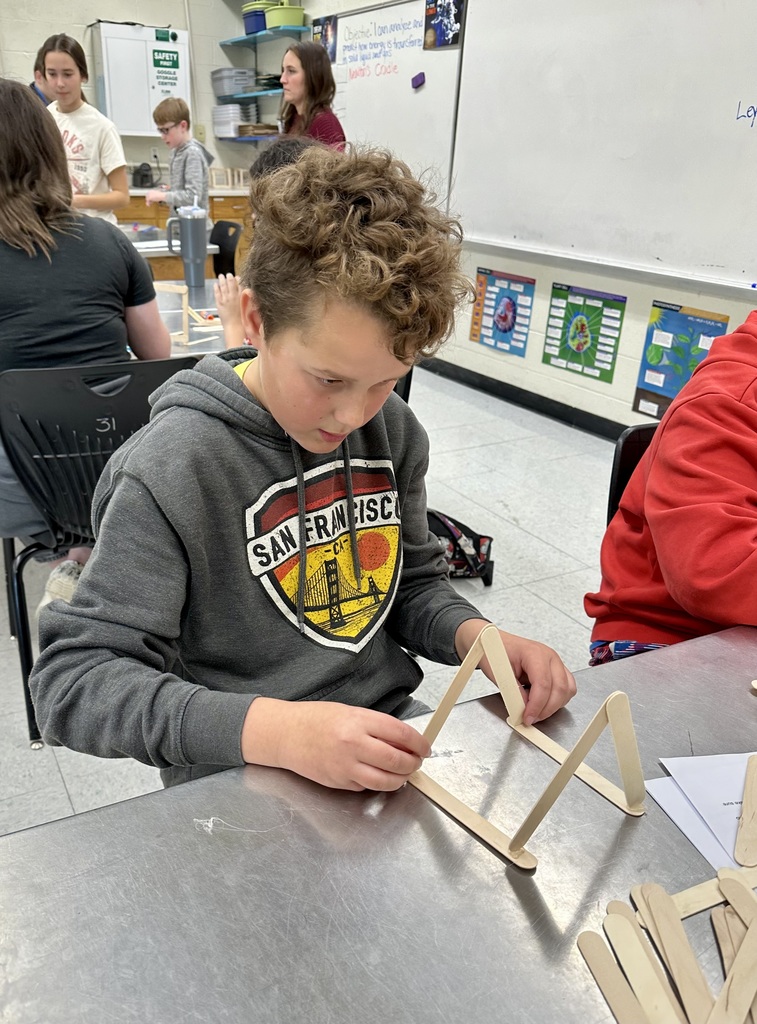 Student gluing popsicle sticks together