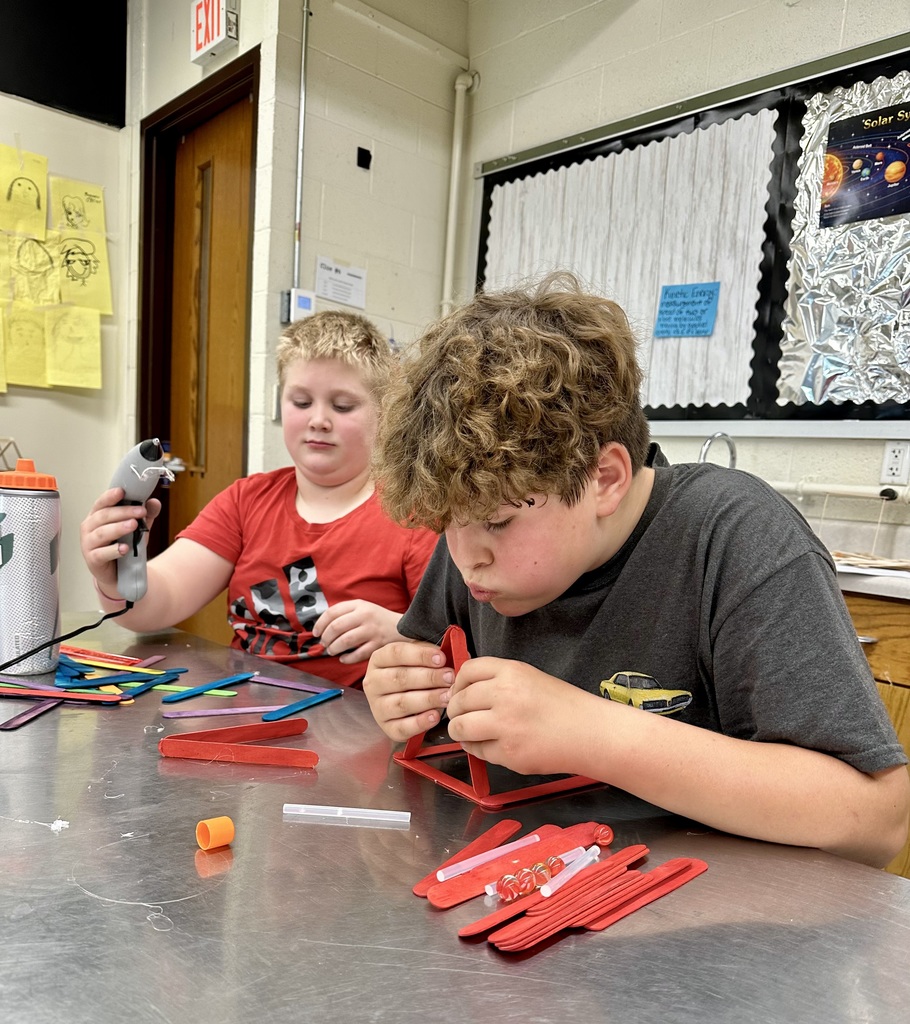 Student gluing popsicle sticks together