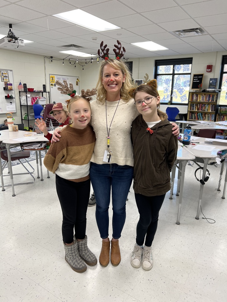 Mrs. Schlabaugh with 2 students dressed as reindeer