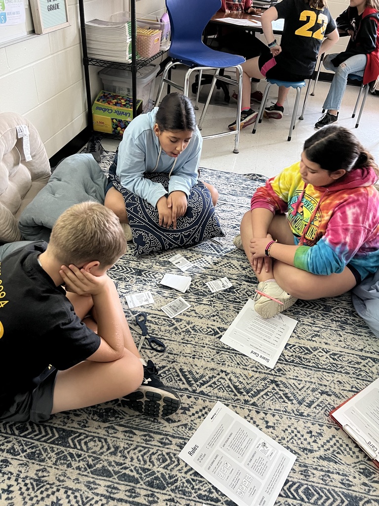 5th graders organizing food chain cards for a science activity