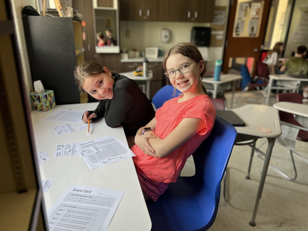5th graders organizing food chain cards for a science activity