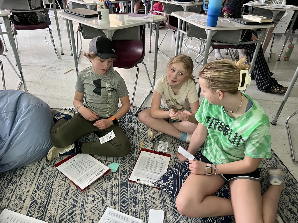 5th graders organizing food chain cards for a science activity