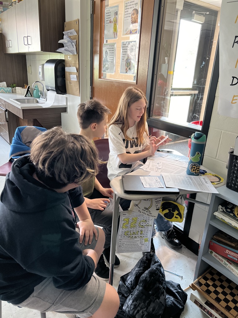 5th graders organizing food chain cards for a science activity