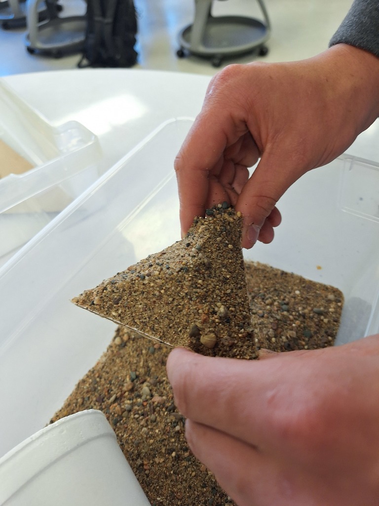 Triangle with sand piled on top for geometry lesson