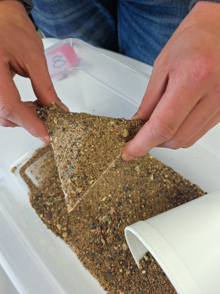 Triangle with sand piled on top for geometry lesson