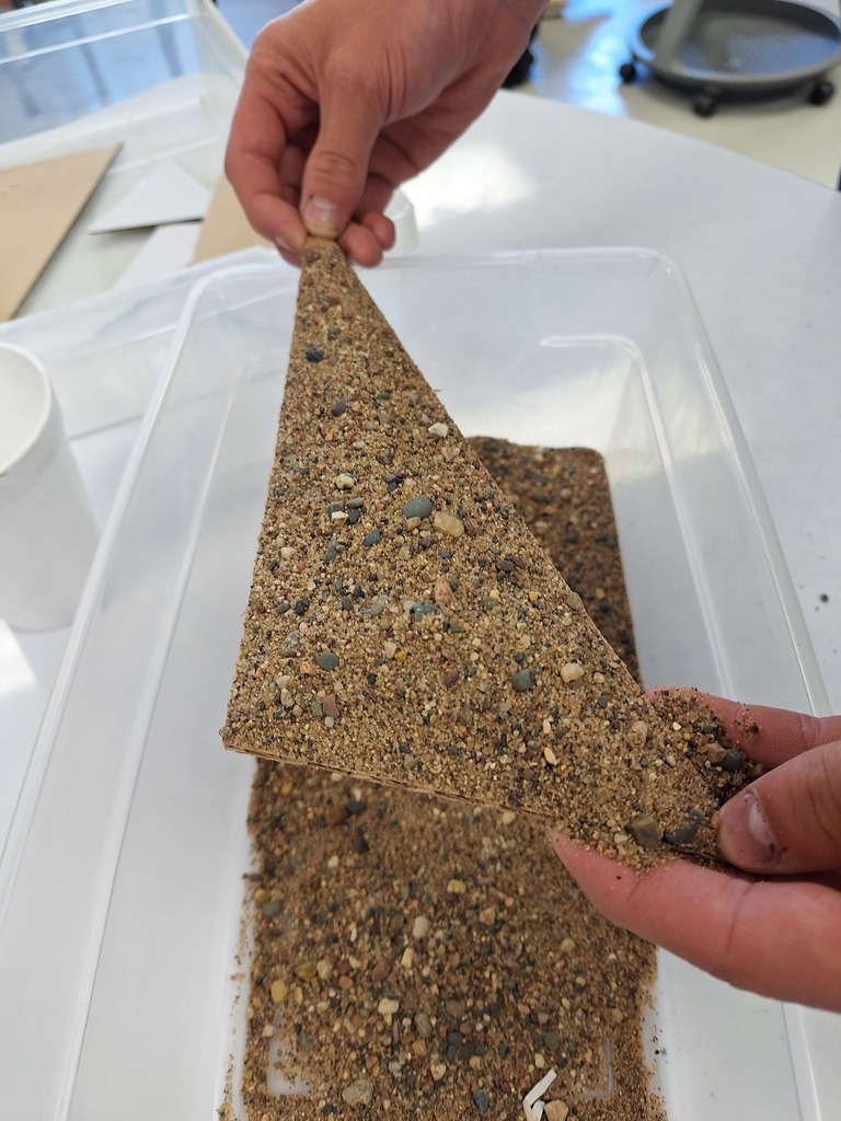 Triangle with sand piled on top for geometry lesson