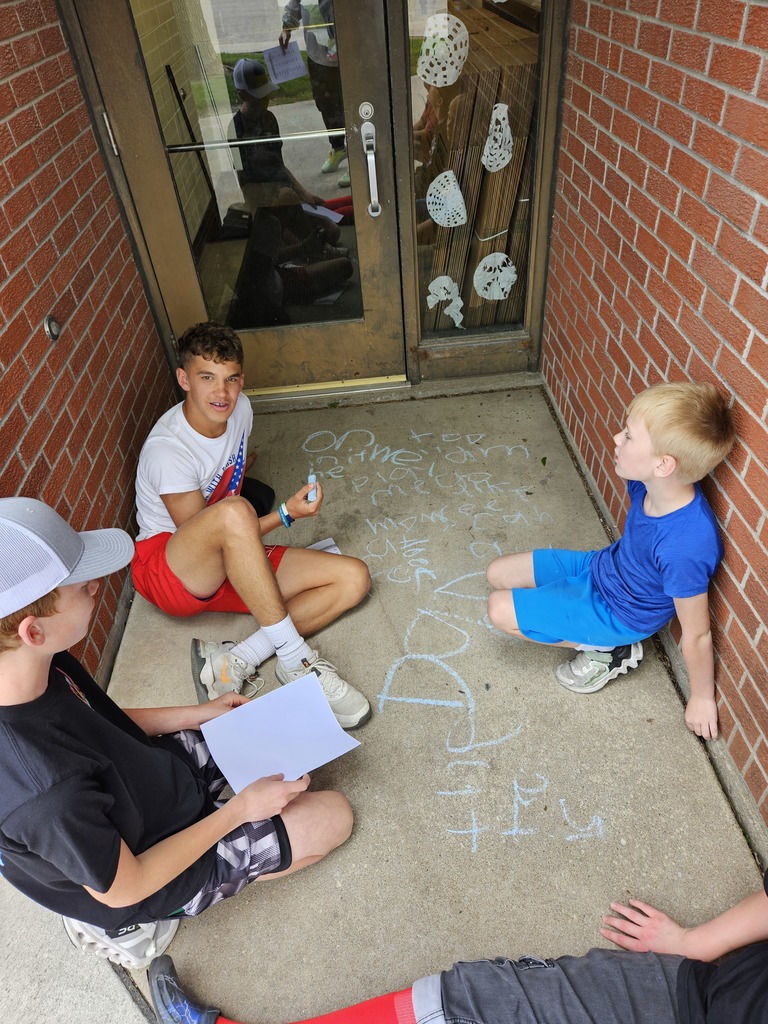 Students writing sight words in sidewalk chalk