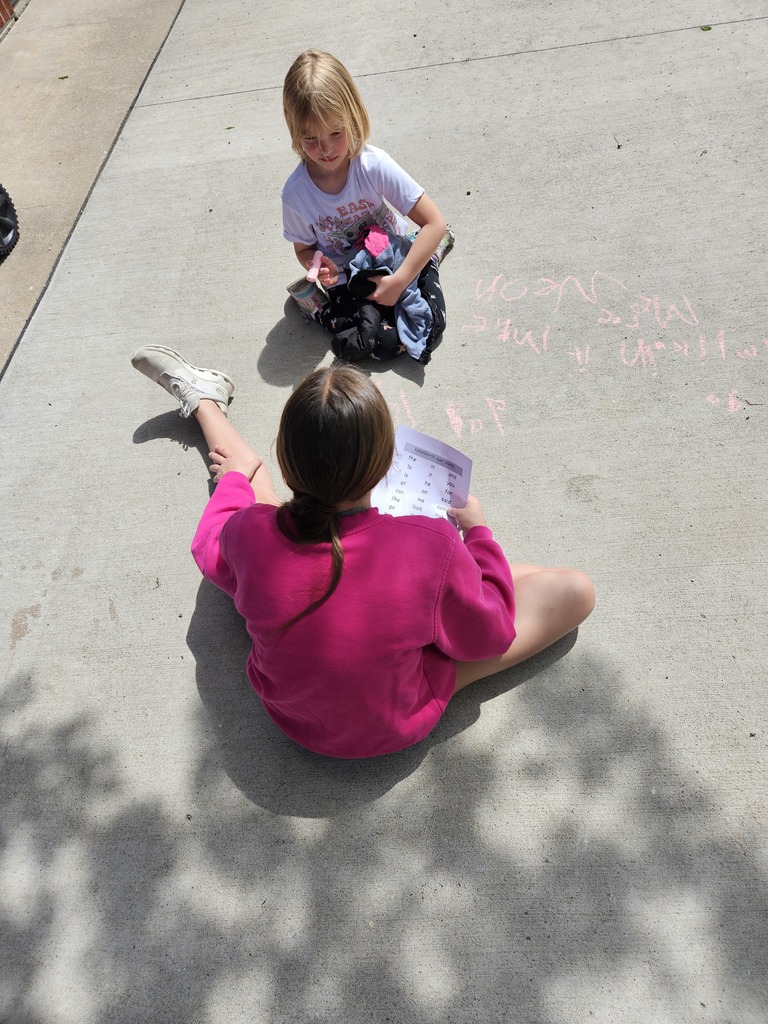 Students practicing writing sight words in sidewalk chalk