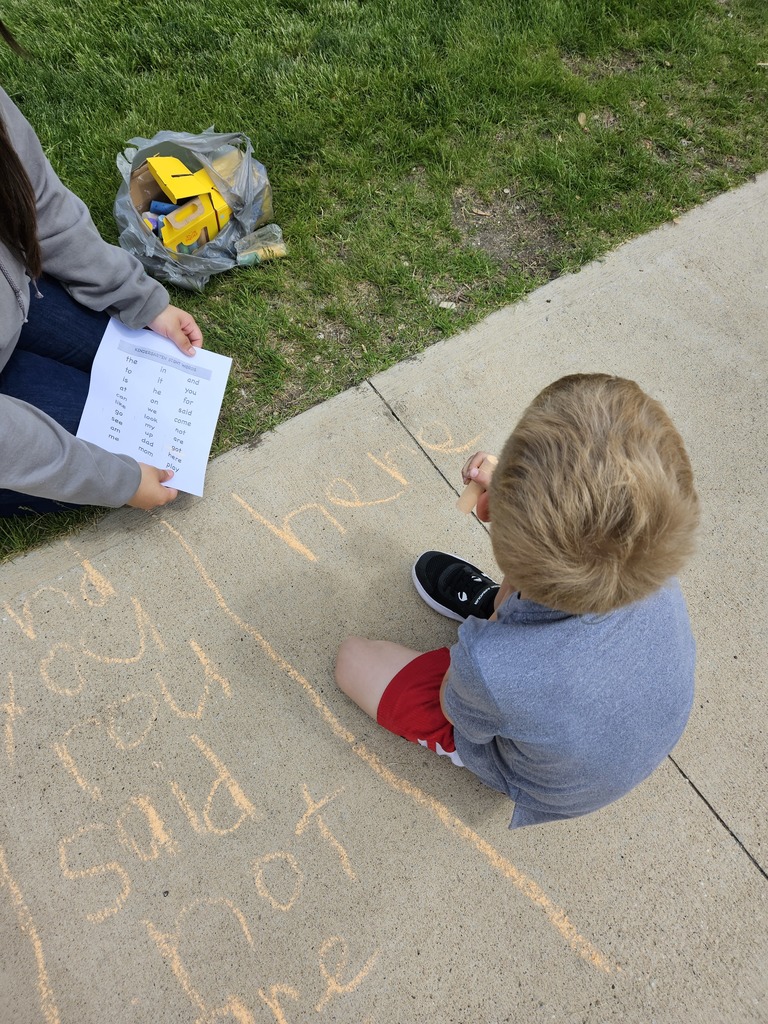 Student writing sight words in sidewalk chalk