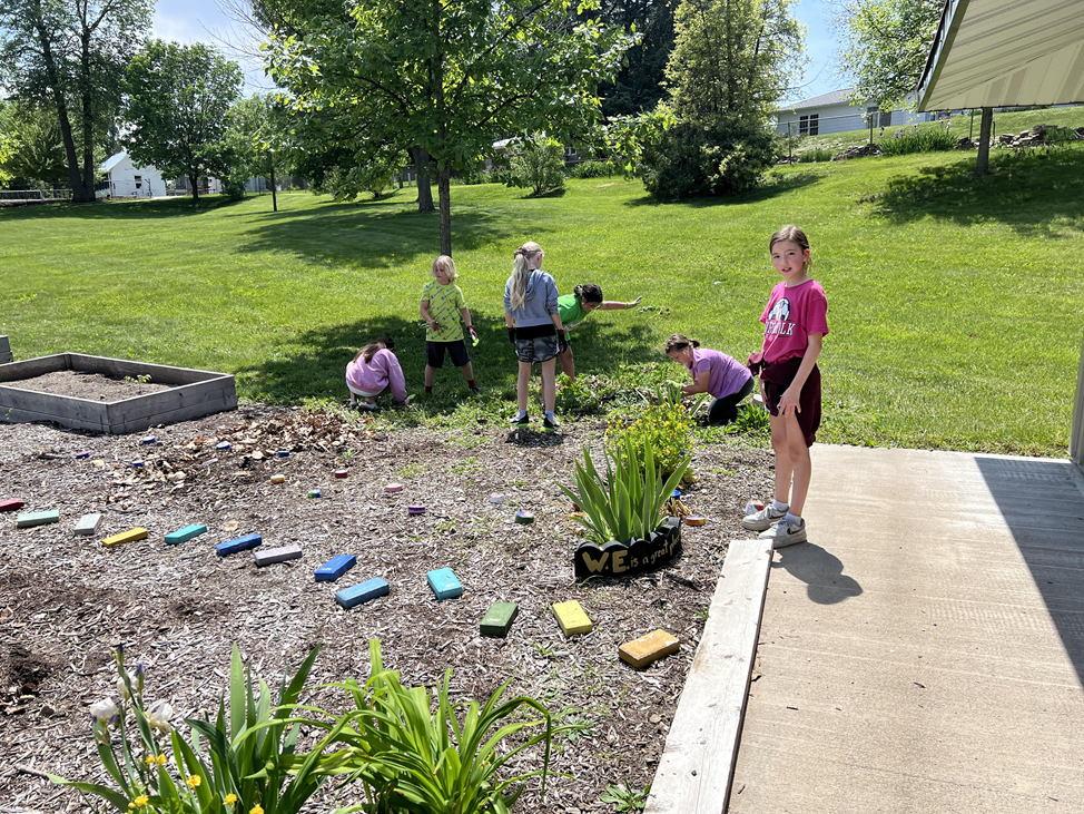 Students building a walking path and pulling weeds in the MP-West school garden