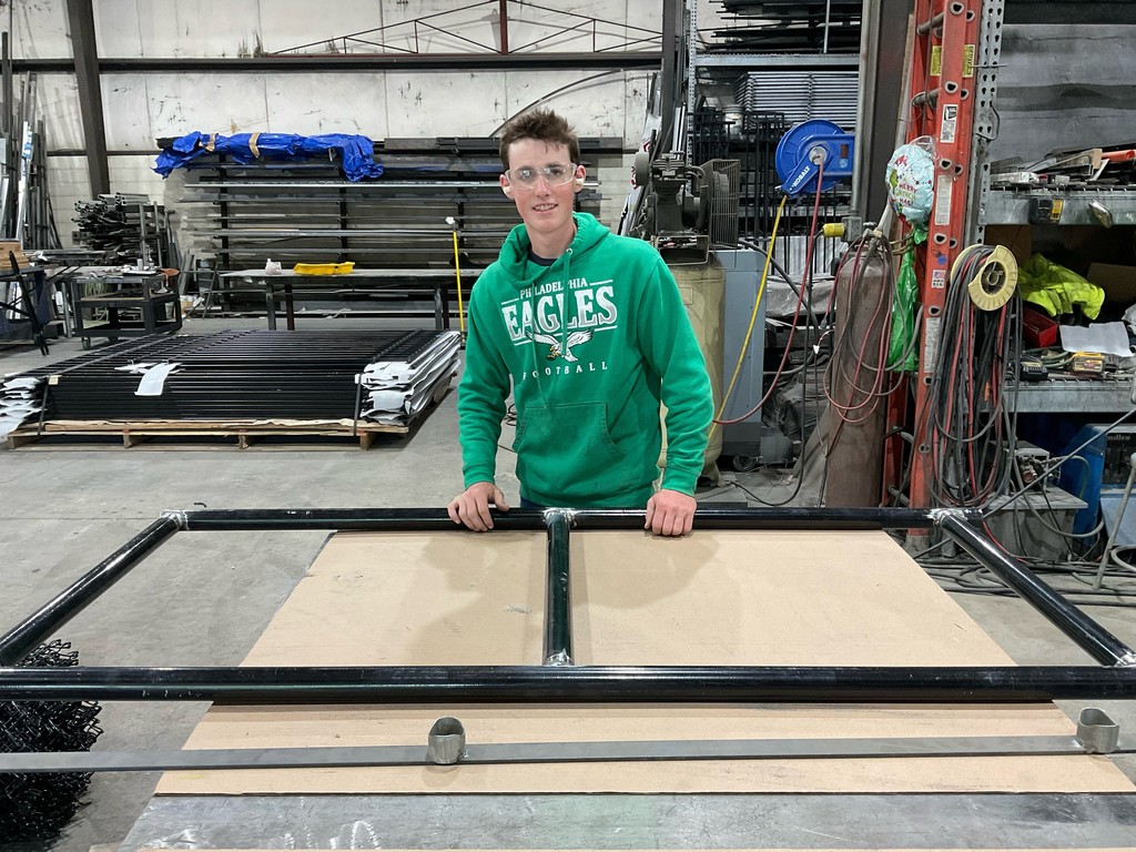 It's a picture of my ball he's standing in the workshop of needles jersey on with safety glasses in front of a frame